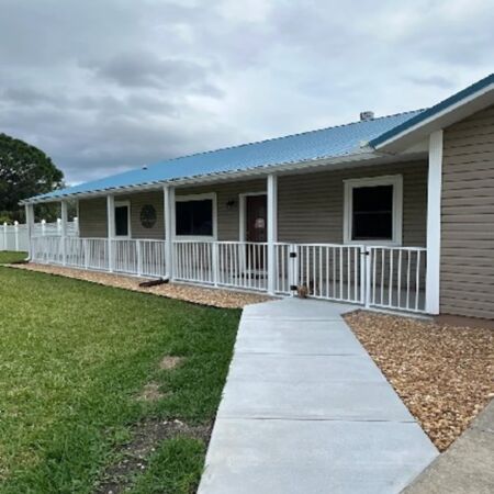 front of house with a white railing described in review